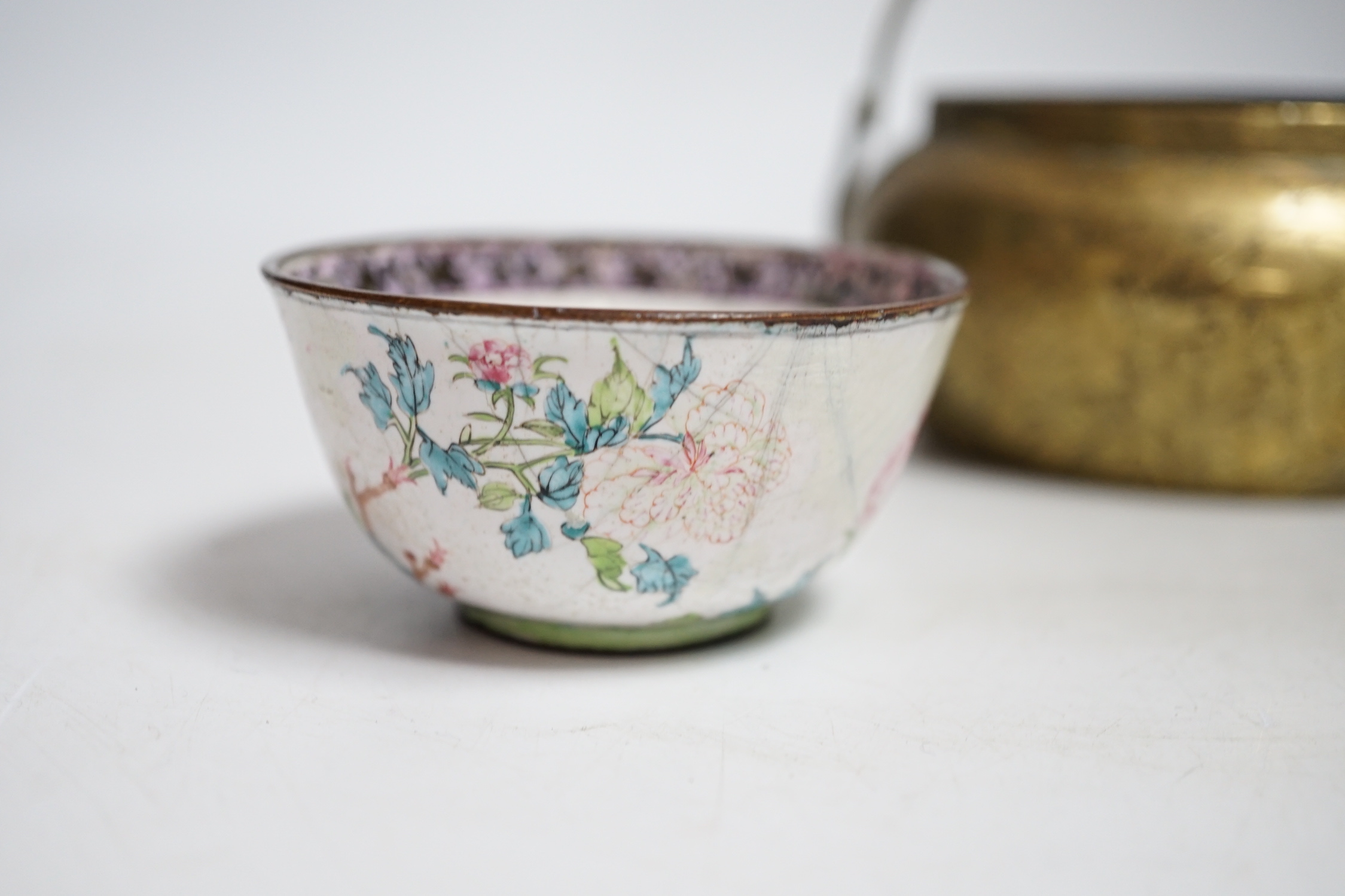 A Chinese bronze hand warmer, 11.3cm and an 18th century Chinese Canton enamel cup, cup 7cm diameter